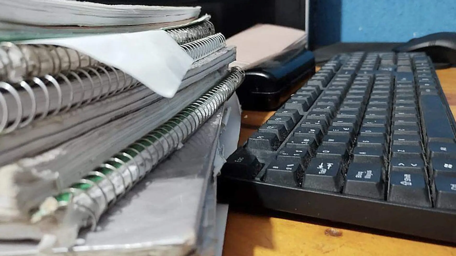 Pila de cuadernos y teclado de computadora